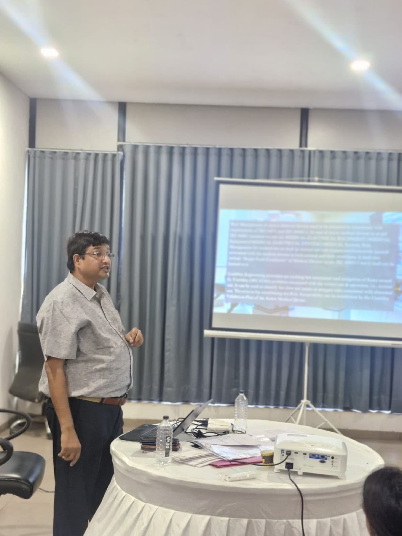 A trainer beside the projector screen at a training session